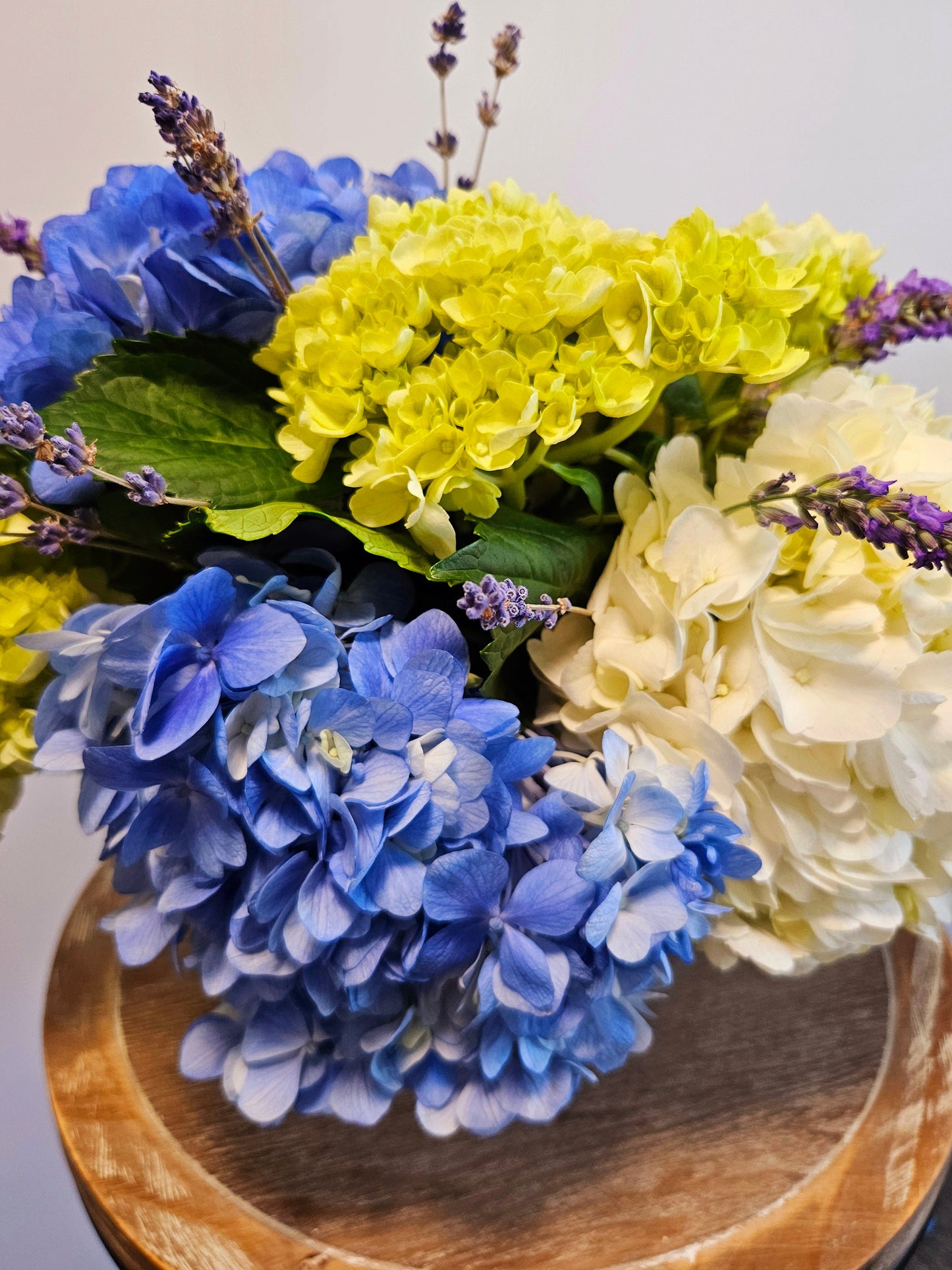 Blue, white and green hydrangea accented with lavender blossoms