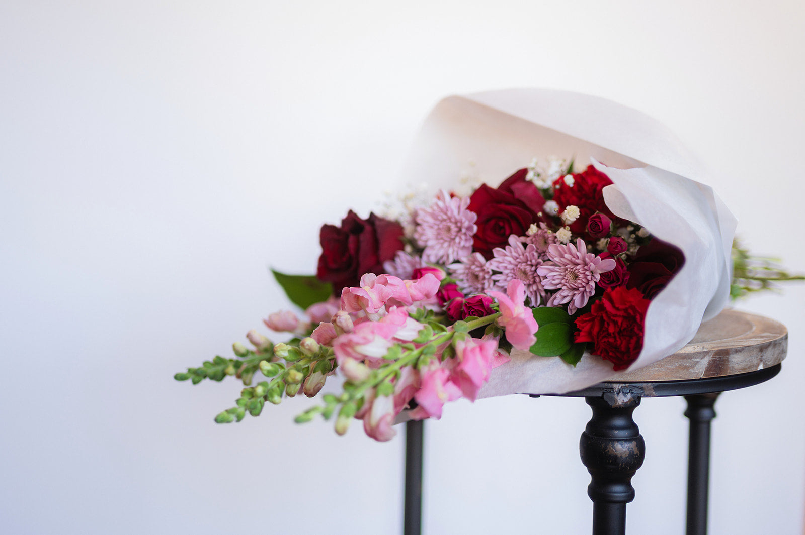 Bouquet of flowers on a wooden stool with a white background